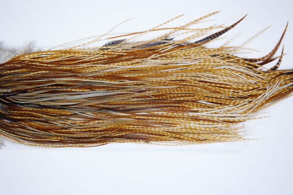 3973 Hebert Dry Fly Hackle, Bronze Grade Rooster Saddle Medium Barred Ginger Ties Size 14-16